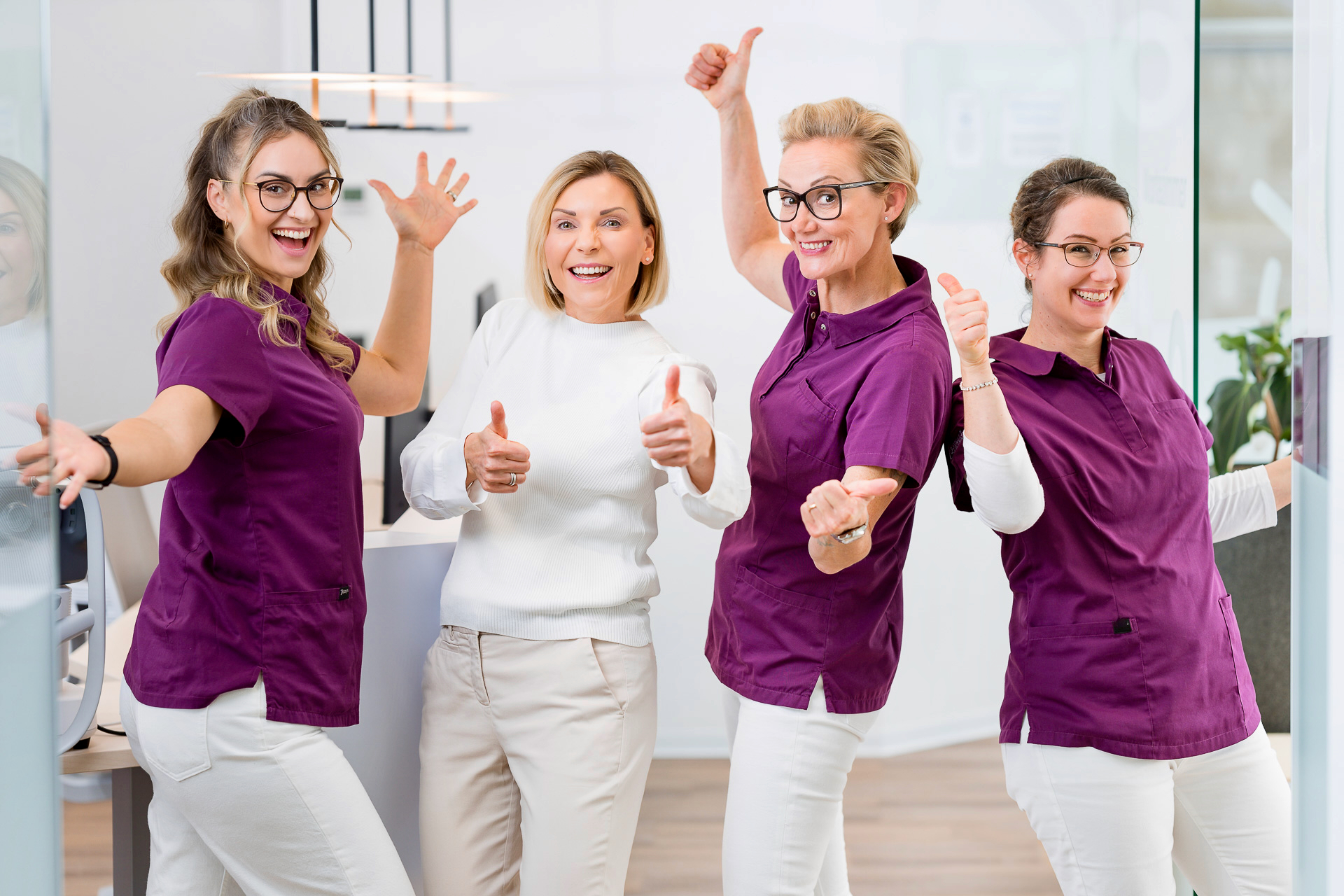 Vier medizinische Fachkräfte in moderner Arztpraxis geben Daumen hoch - Stellenangebote für Ärzte in der Niederlassung