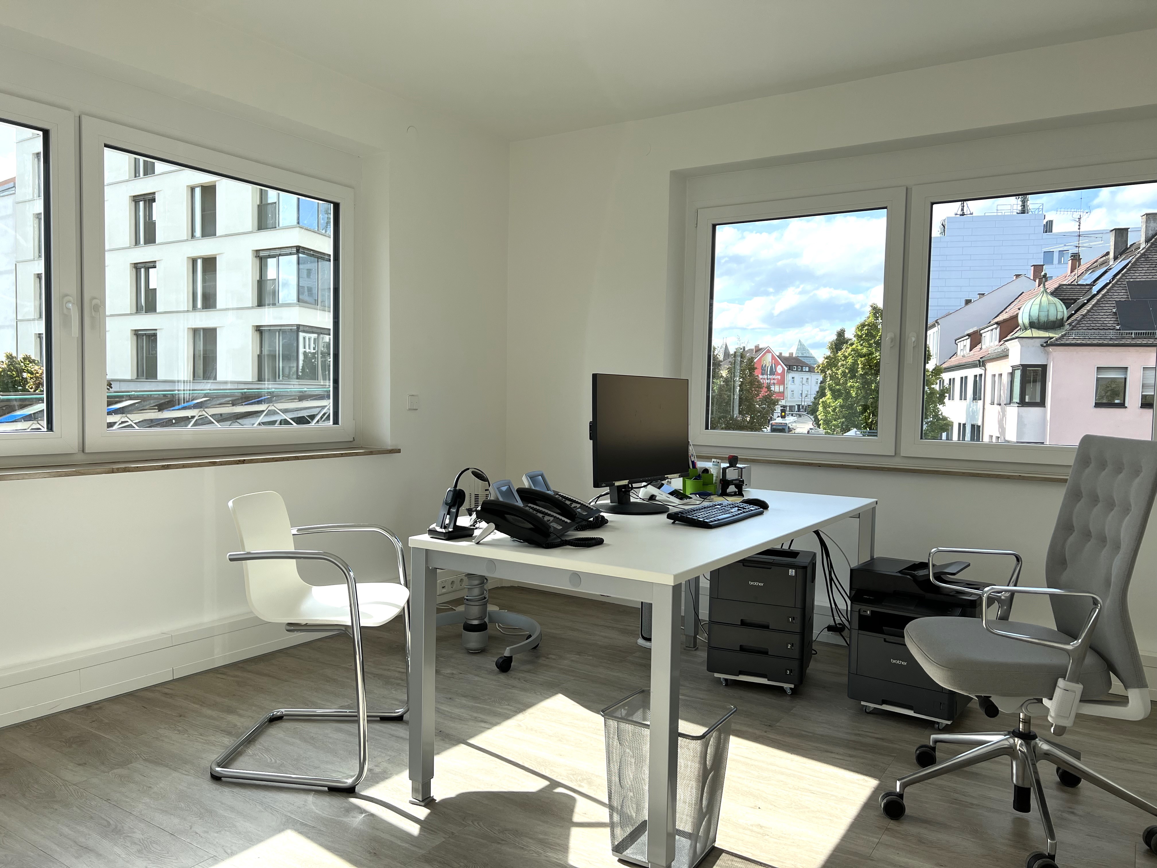 Helles Büro mit Schreibtisch und Stadtblick in einer Arztpraxis vor der Praxisübergabe