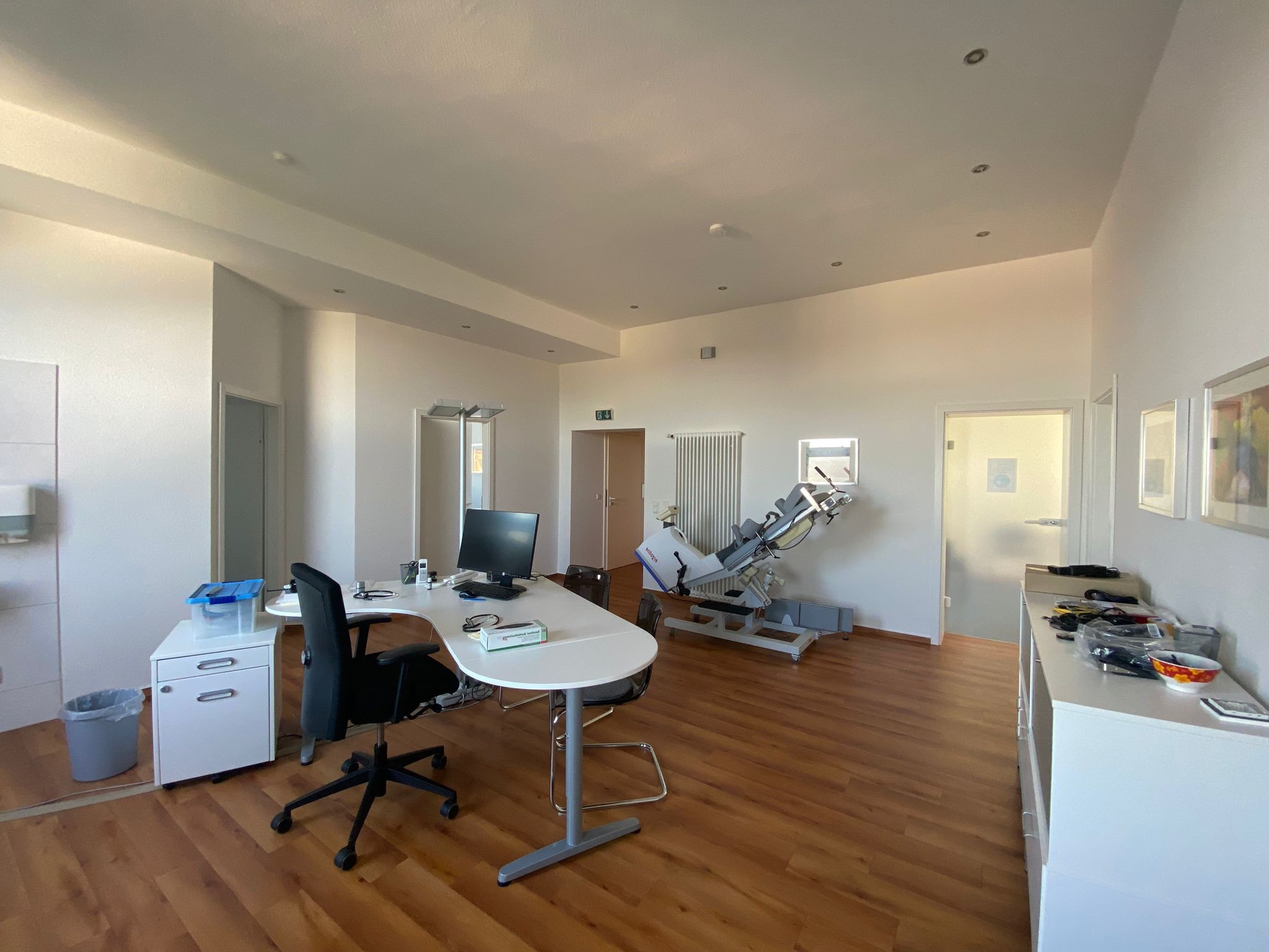 Praxisabgabe - geräumiger Behandlungsraum mit Schreibtisch, Untersuchungsstuhl und medizinischer Ausstattung