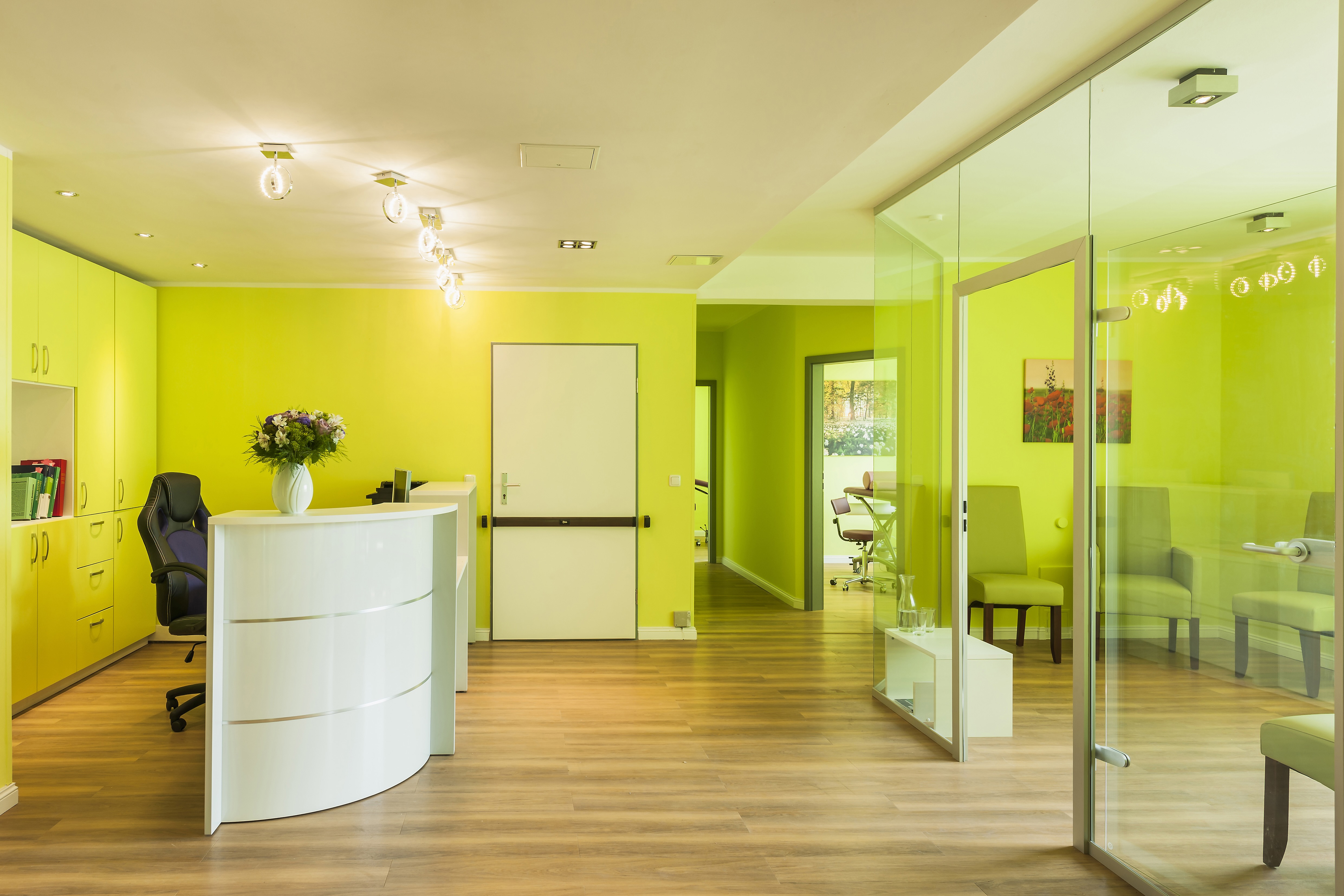 Praxisabgabe - heller Empfangsbereich mit grünem Farbkonzept und moderner Ausstattung in einer Arztpraxis