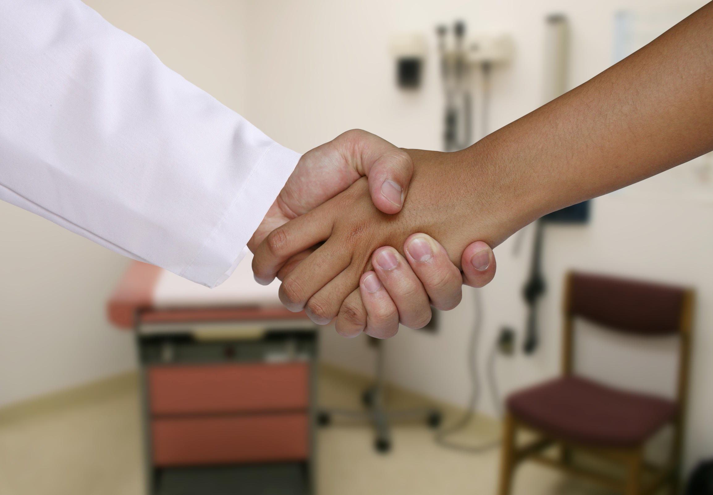 Händedruck zwischen Arzt und Patient als Zeichen für digitale Zusammenarbeit, Praxisdigitalisierung und moderne Praxissoftware mit KI