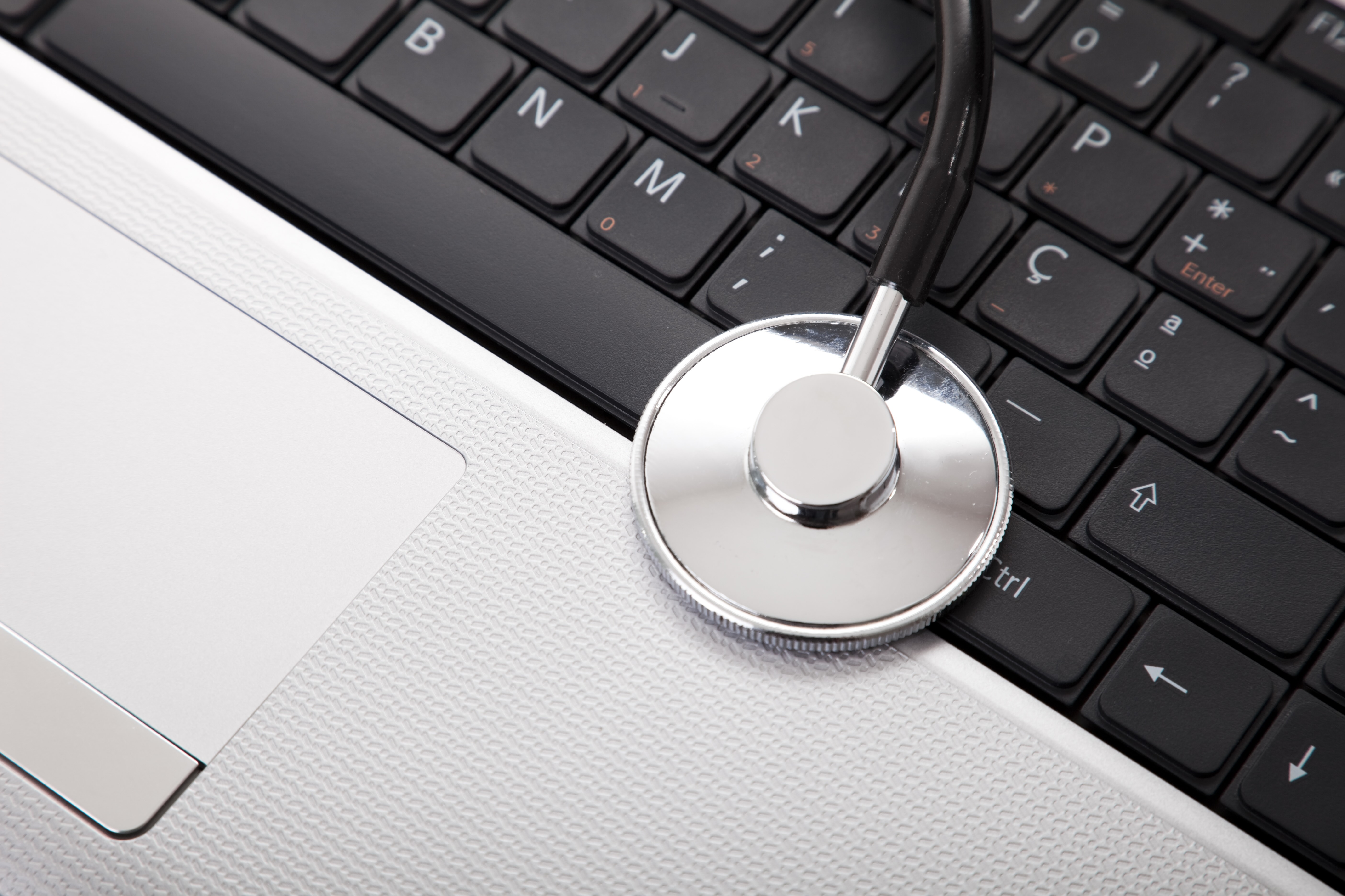 Stethoskop auf Laptop-Tastatur – Symbol für medizinische IT-Sicherheit, digitale Praxissoftware und Datenschutz in der Arztpraxis